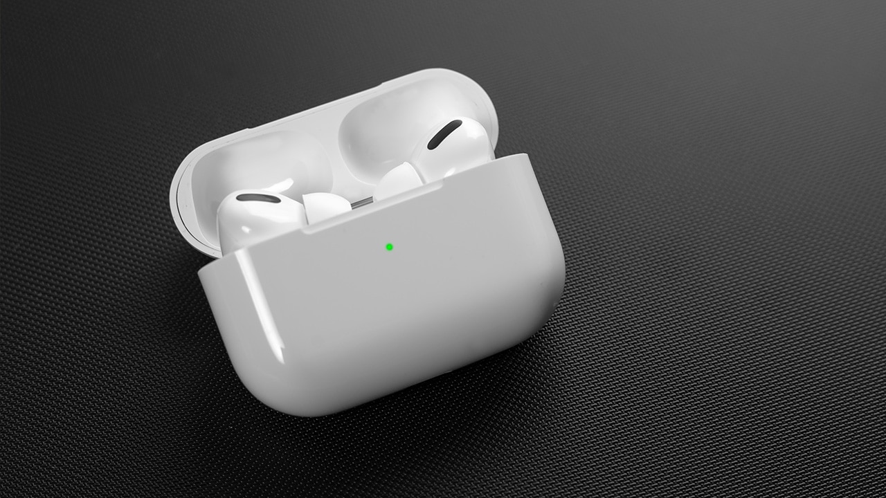 Image: AirPods Pro in case on black mesh background.