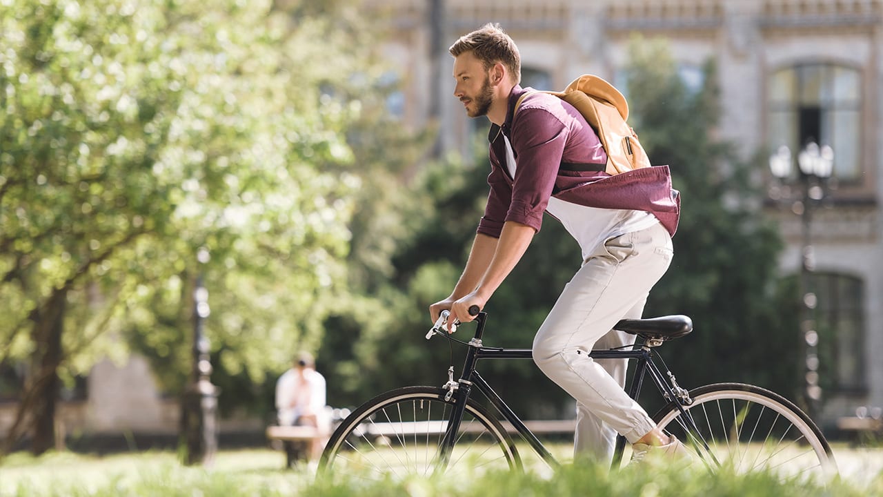 Image: Man riding bike in park.