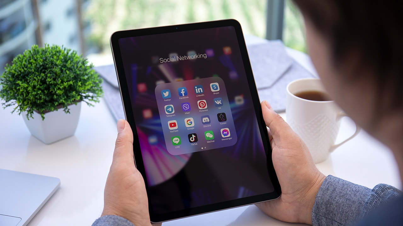 Image: Person looking at app folder on an iPad.